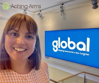 staff member Claire, with Global's logo in the background on a large screen.